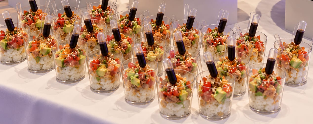 Rangées de verrines de riz tartare, chacune avec sa pipette de sauce soja