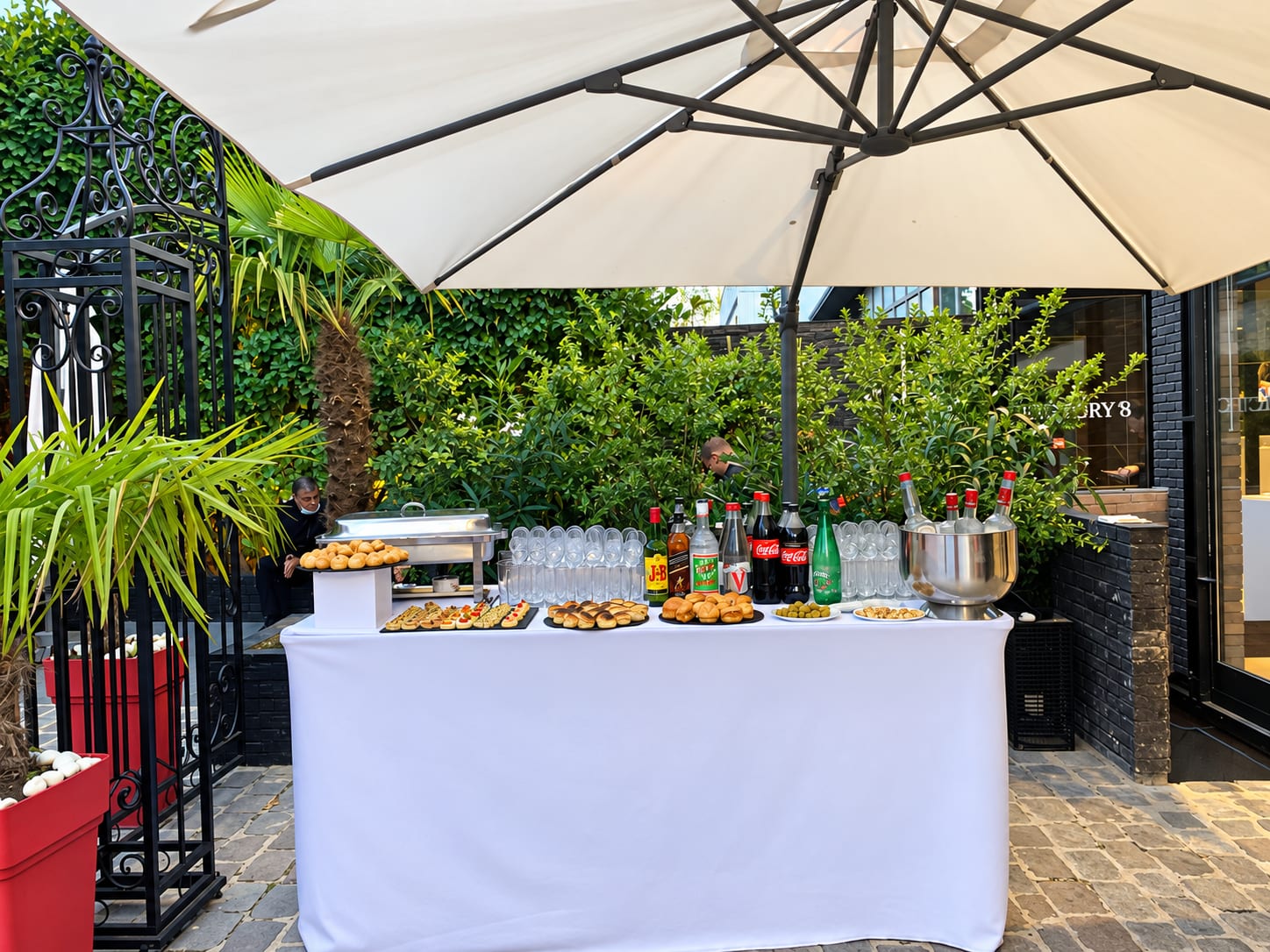 Bar du cocktail dressé en terrasse, sous un grand parasol
